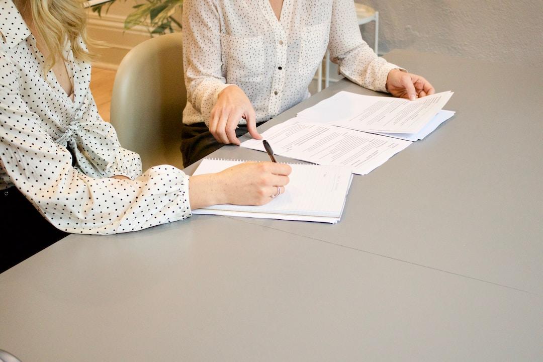 Two businesswomen at a desk discussing examples of sales leadership and how it impacts their revenue